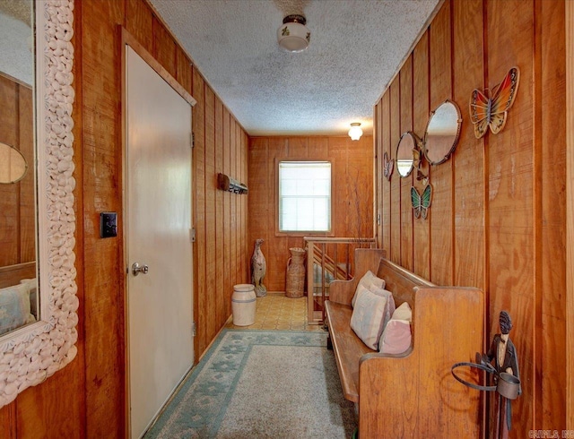 interior space featuring a textured ceiling and wooden walls