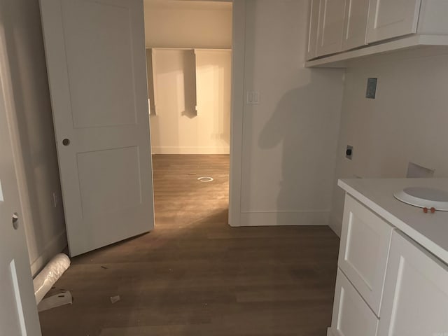 laundry area with sink, electric dryer hookup, cabinets, and dark hardwood / wood-style flooring