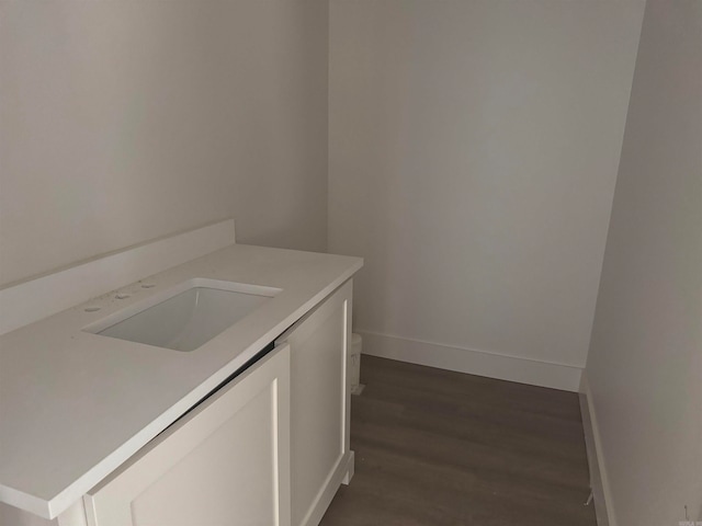 clothes washing area with sink and dark hardwood / wood-style floors