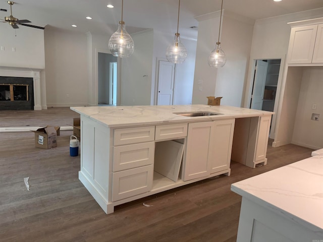 kitchen featuring white cabinets, light stone counters, dark hardwood / wood-style floors, and hanging light fixtures