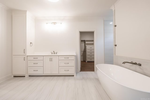 bathroom featuring vanity, crown molding, and a washtub