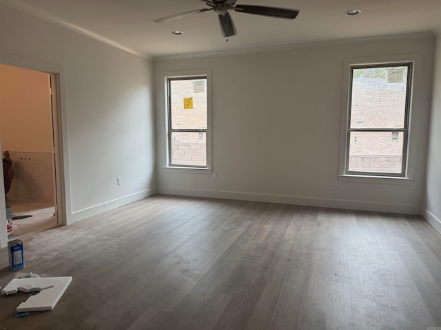 spare room with crown molding, wood-type flooring, and ceiling fan