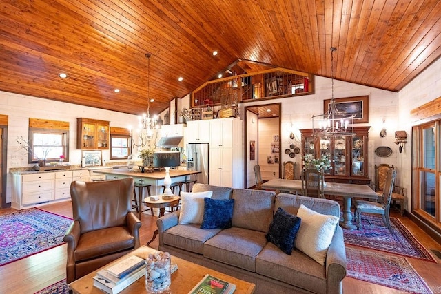 living room with high vaulted ceiling, wooden ceiling, an inviting chandelier, wooden walls, and hardwood / wood-style floors