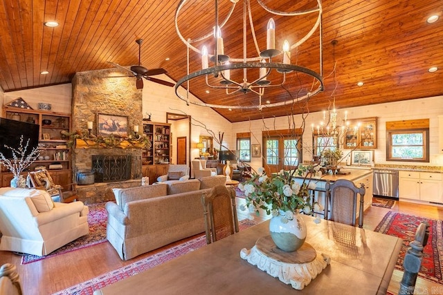 dining space with wooden ceiling, ceiling fan with notable chandelier, a fireplace, and light wood-type flooring