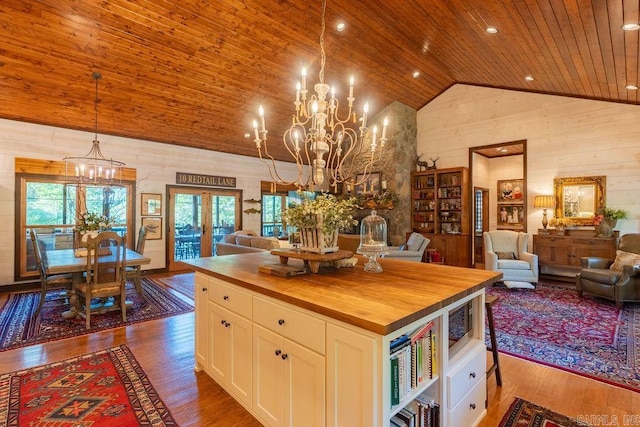 kitchen featuring wood ceiling, white cabinets, a kitchen island, wooden counters, and decorative light fixtures