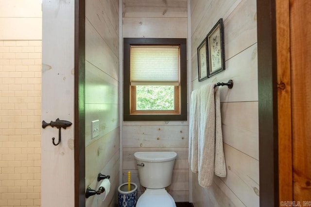 bathroom featuring tile walls and toilet