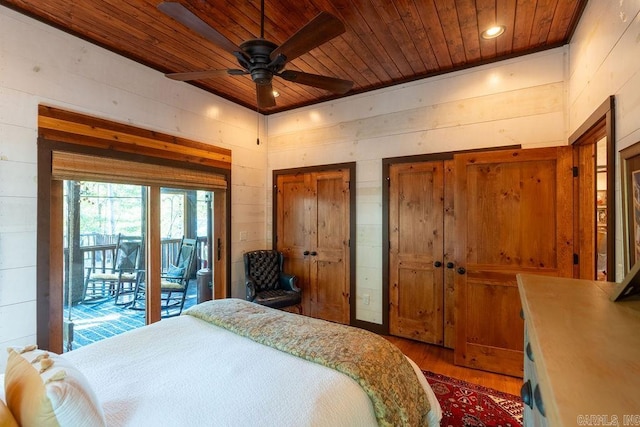 bedroom with wood-type flooring, wood ceiling, wood walls, and ceiling fan