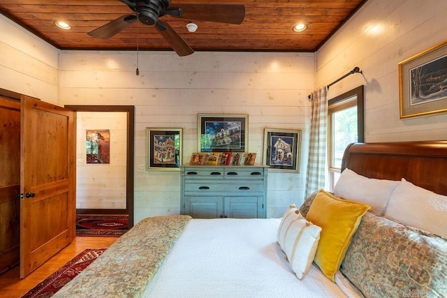 bedroom with wood-type flooring, wooden walls, ceiling fan, and wooden ceiling