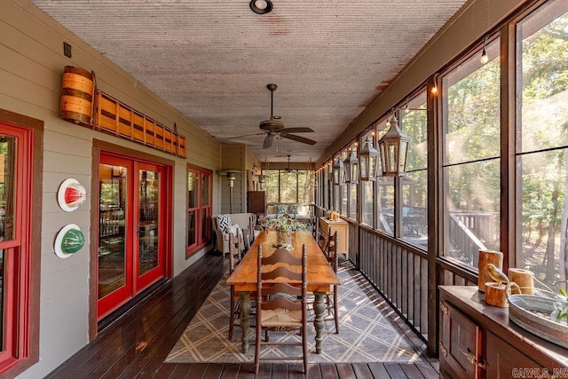 unfurnished sunroom with ceiling fan