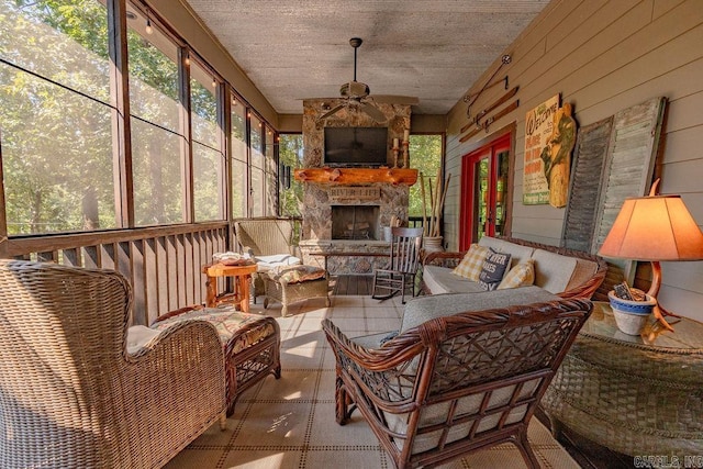 sunroom with an outdoor stone fireplace