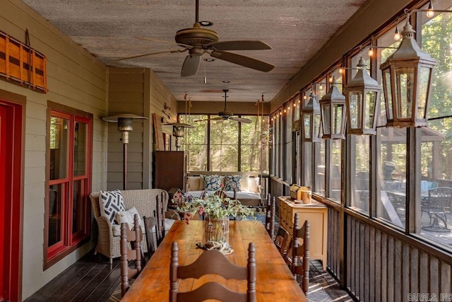 unfurnished sunroom with ceiling fan