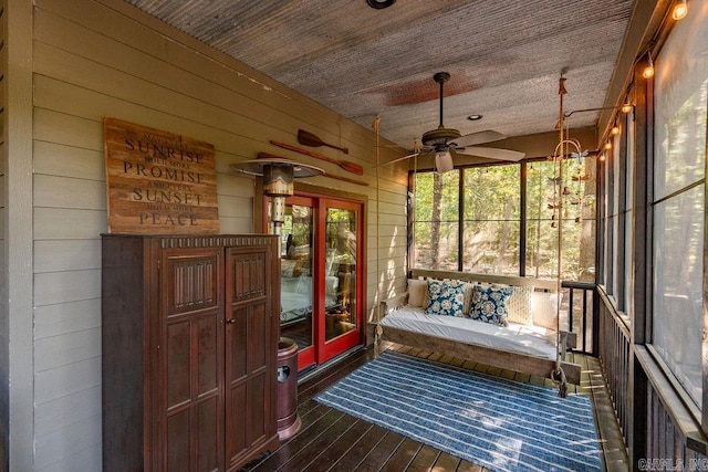 sunroom with ceiling fan with notable chandelier