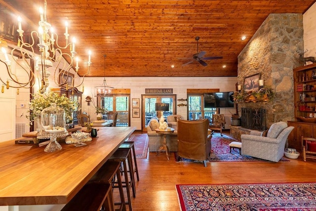 living room featuring wood-type flooring, high vaulted ceiling, a fireplace, wooden ceiling, and ceiling fan with notable chandelier