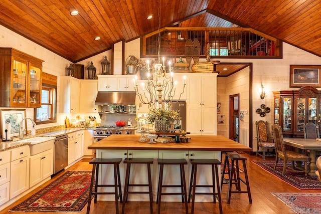 kitchen featuring a center island, butcher block counters, exhaust hood, wooden ceiling, and stainless steel dishwasher