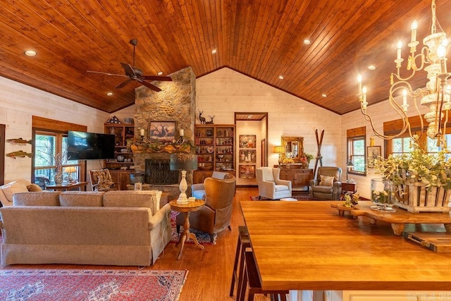 living room with wood ceiling, a stone fireplace, ceiling fan, and a wealth of natural light