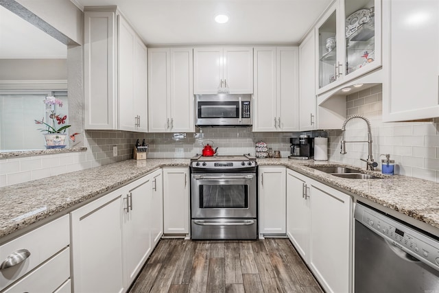 kitchen featuring white cabinets, stainless steel appliances, backsplash, and dark hardwood / wood-style flooring