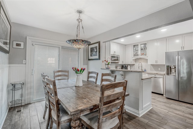 dining space featuring light hardwood / wood-style flooring and sink