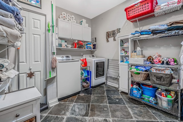 washroom featuring cabinets and washer and clothes dryer