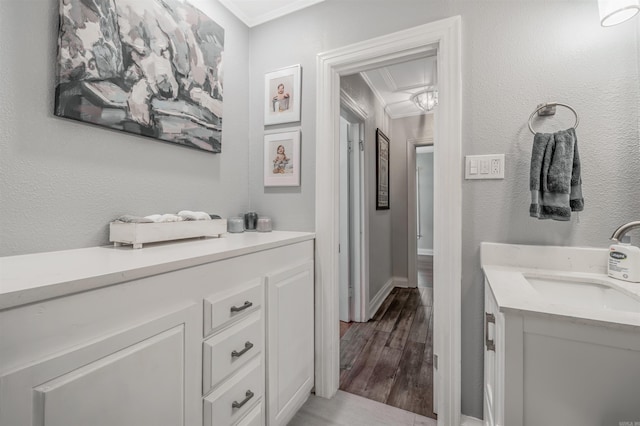 bathroom featuring ornamental molding, hardwood / wood-style flooring, and vanity