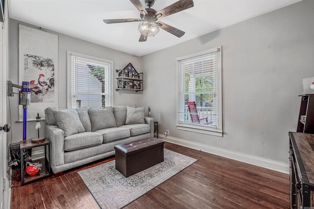 living room featuring ceiling fan and dark wood-type flooring