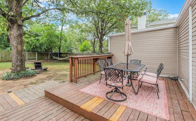 wooden terrace featuring a lawn