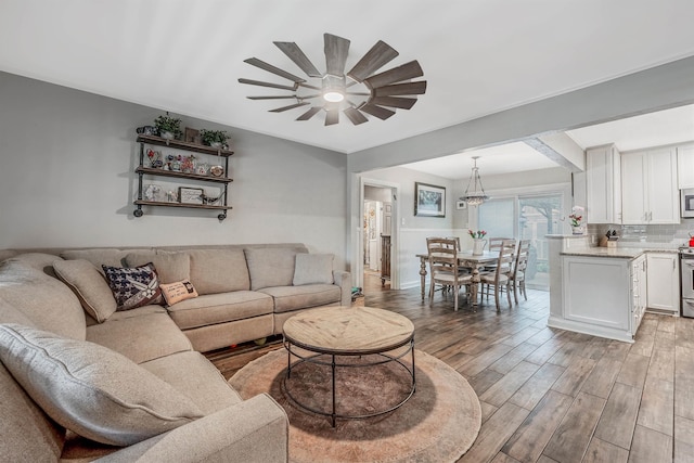 living room with ceiling fan and hardwood / wood-style flooring