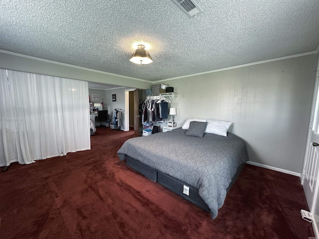 carpeted bedroom with a textured ceiling and crown molding