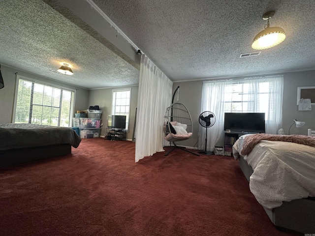 carpeted bedroom featuring multiple windows and a textured ceiling