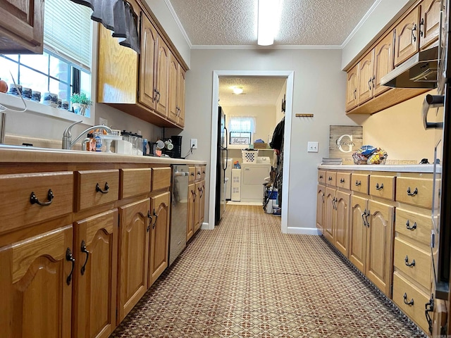 kitchen with a textured ceiling, crown molding, fridge, stainless steel dishwasher, and washer and dryer