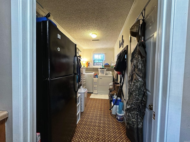 kitchen featuring ornamental molding, a textured ceiling, independent washer and dryer, and black fridge