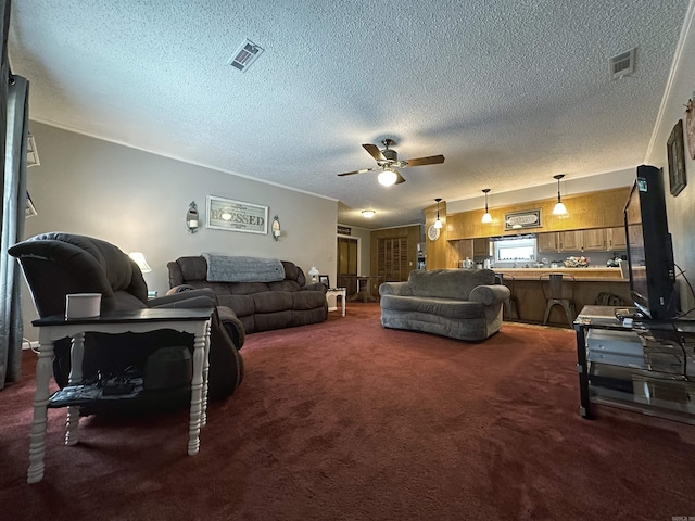 living room with a textured ceiling, ceiling fan, and carpet floors