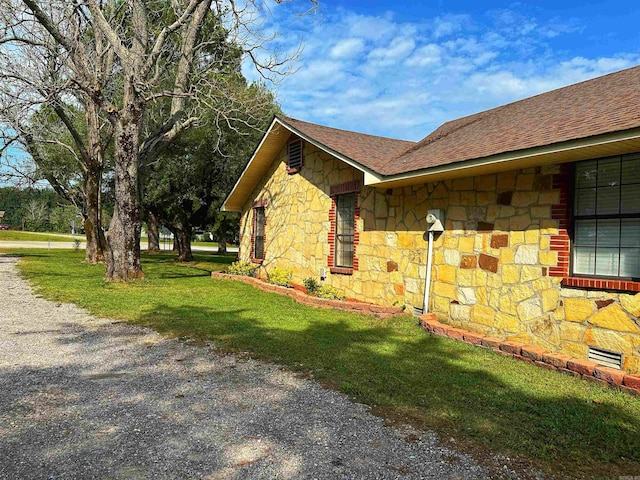 view of side of home with a yard