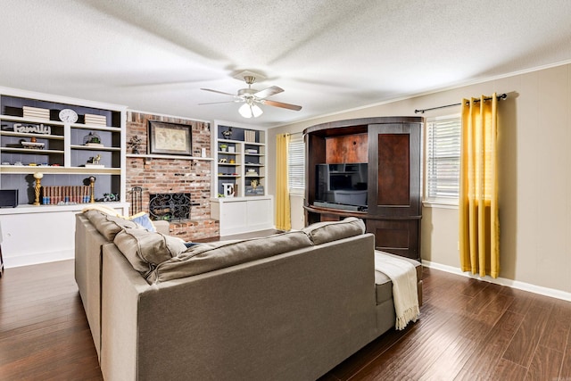 living room featuring ceiling fan, built in features, a textured ceiling, a fireplace, and dark hardwood / wood-style flooring