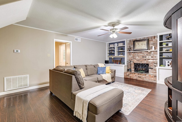 living room featuring ceiling fan, a textured ceiling, a fireplace, and dark hardwood / wood-style floors