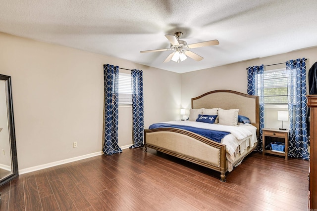 bedroom with ceiling fan, a textured ceiling, and dark wood-type flooring