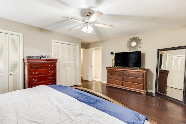 bedroom with ceiling fan, multiple closets, and dark hardwood / wood-style floors