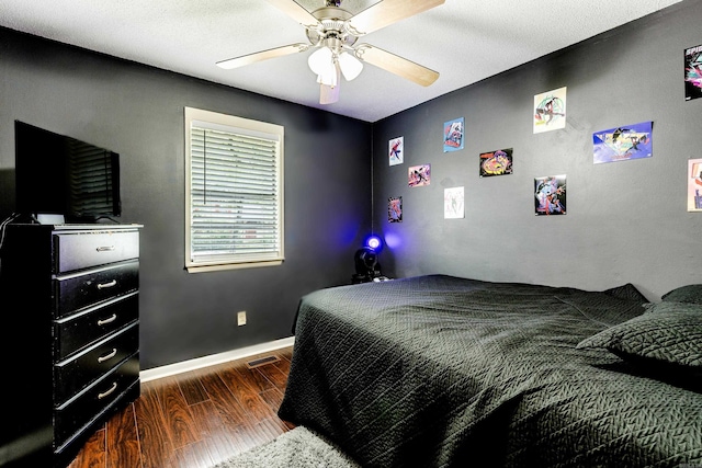 bedroom featuring ceiling fan, a textured ceiling, and dark hardwood / wood-style floors