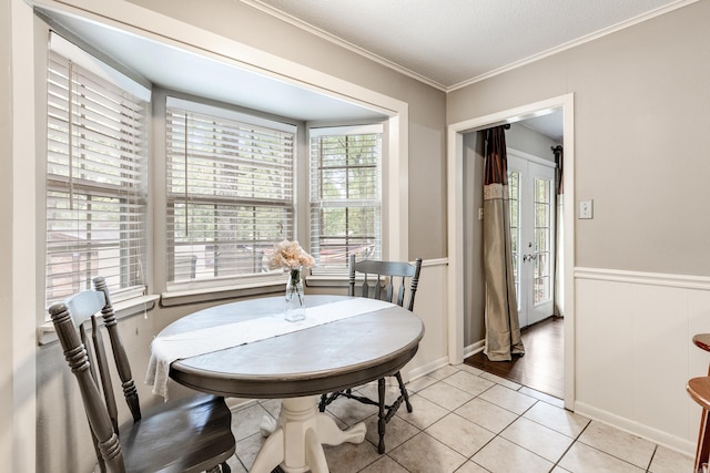 tiled dining room with a textured ceiling and crown molding