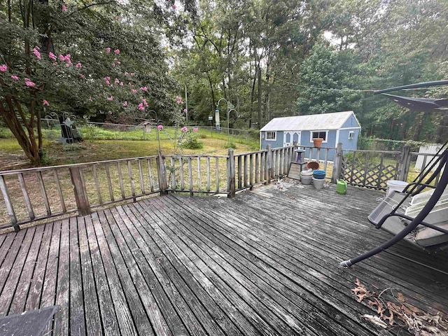 wooden deck featuring a storage unit and a yard