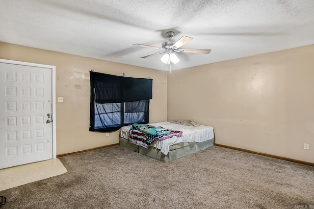 carpeted bedroom featuring a textured ceiling and ceiling fan