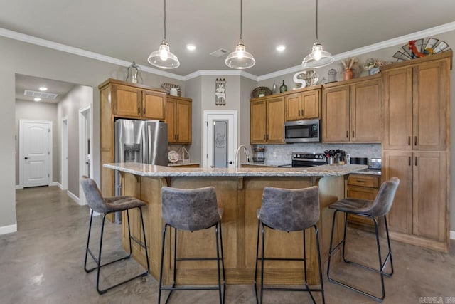 kitchen featuring a kitchen island with sink, a breakfast bar, pendant lighting, and appliances with stainless steel finishes