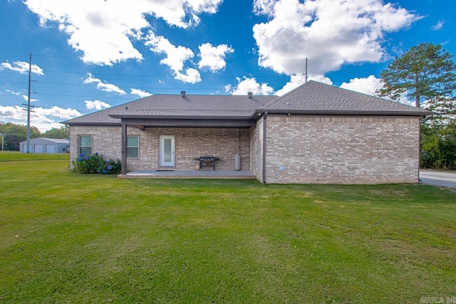 rear view of house with a yard and a patio