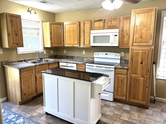 kitchen featuring white appliances, sink, and ceiling fan