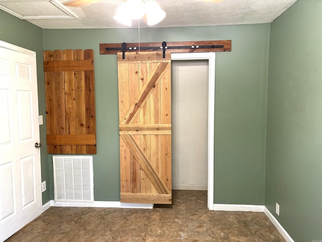 interior space featuring a barn door and a textured ceiling