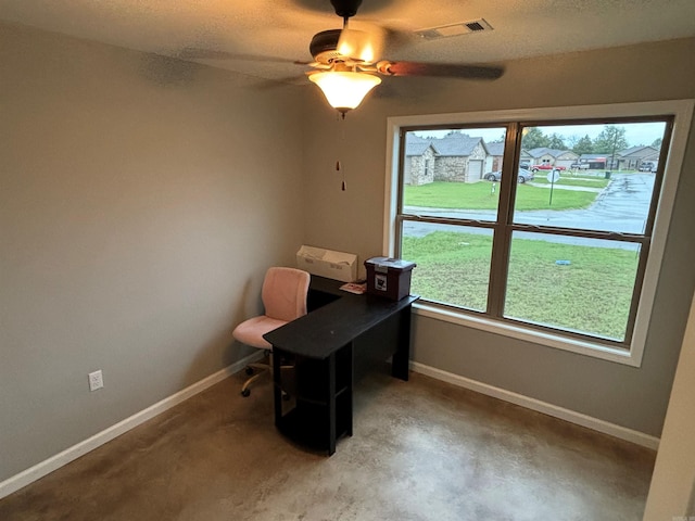 office featuring concrete floors, ceiling fan, and a textured ceiling