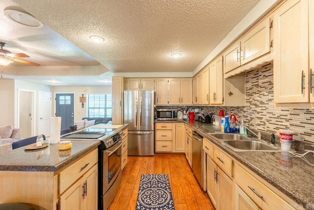 kitchen featuring light hardwood / wood-style floors, light brown cabinets, ceiling fan, and stainless steel appliances