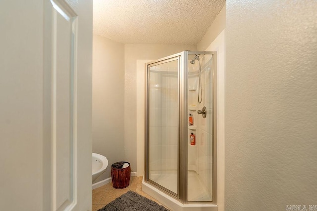 bathroom with walk in shower, a textured ceiling, and tile patterned floors