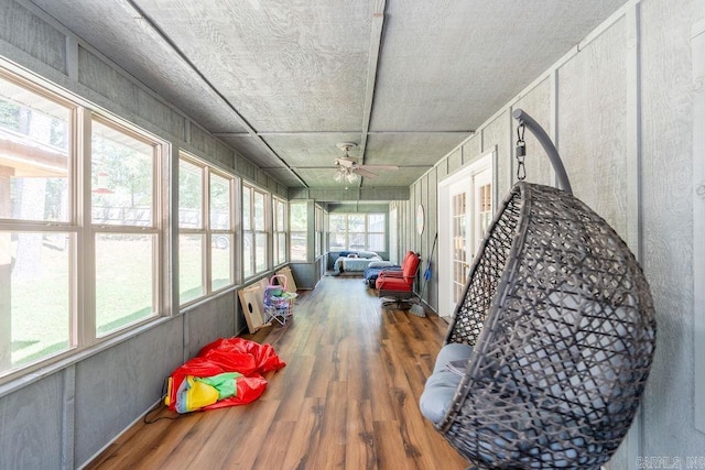 sunroom featuring ceiling fan and plenty of natural light