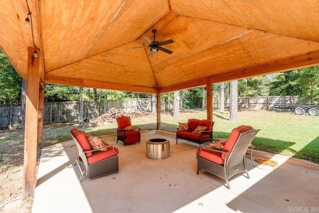 view of patio featuring ceiling fan and an outdoor living space with a fire pit