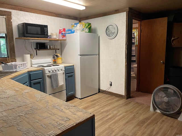 kitchen featuring blue cabinets, white refrigerator, stainless steel range, light hardwood / wood-style floors, and butcher block counters